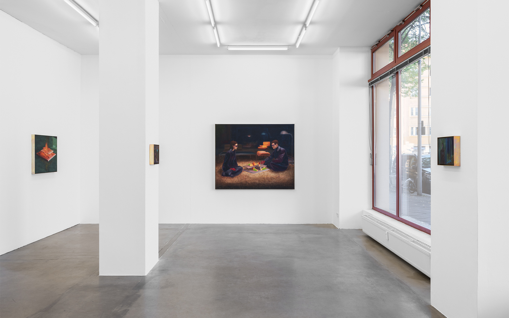 Weiße Kunstgalerie mit zentraler Säule; Leinwandbild zeigt zwei Personen am Feuer; rechts großes Fenster mit roten Rahmen.